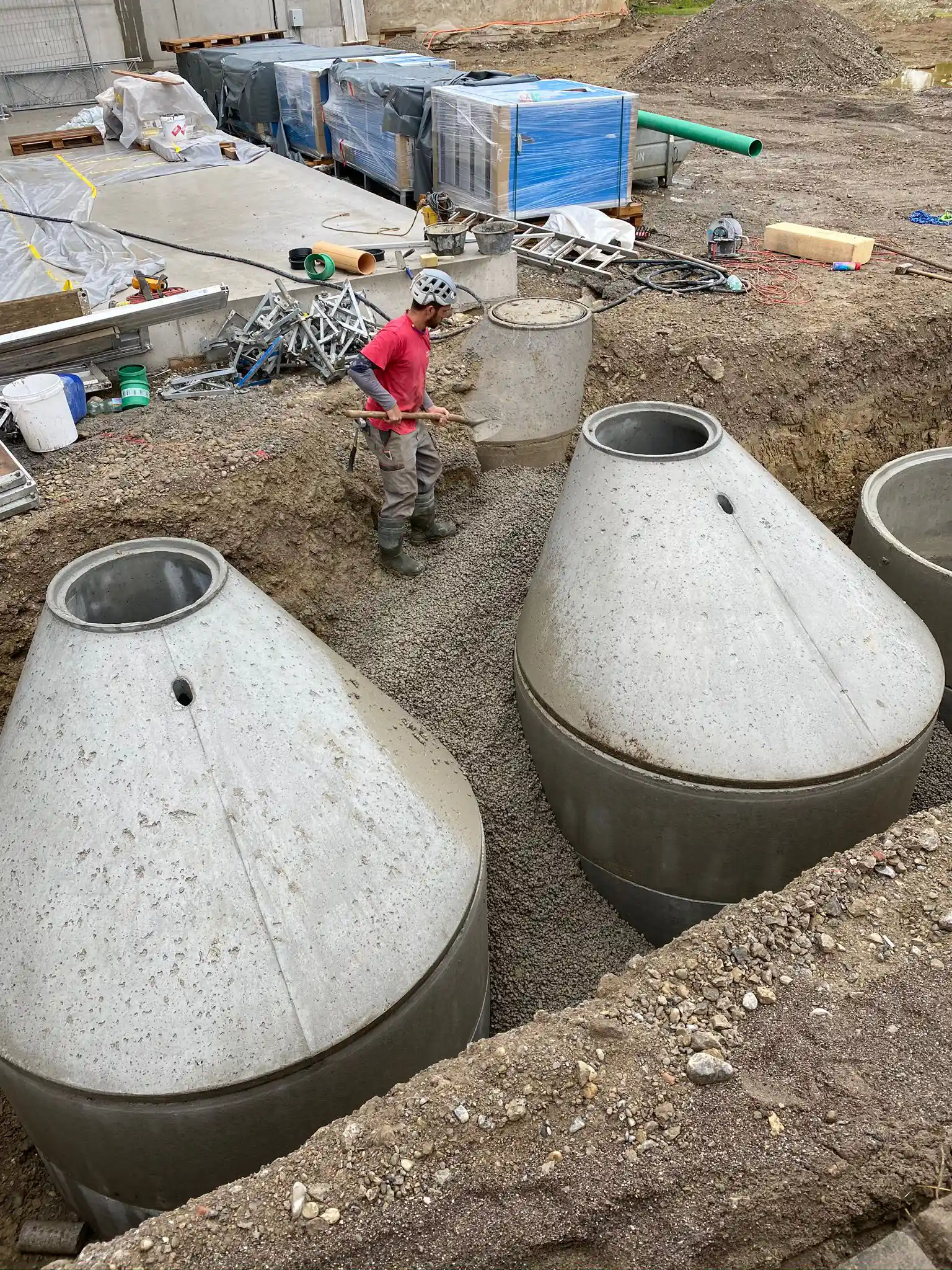 Betonzisternen (Regenwasser-Sammelbehälter), die gerade eingegraben werden.
